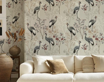 May include: A living room with a white couch and a coffee table. The wall is covered in wallpaper with a pattern of gray cranes and floral branches.