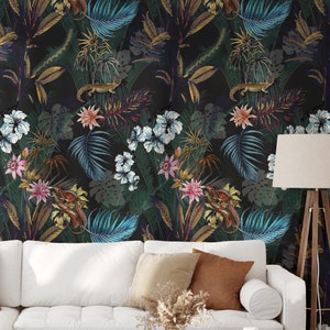 Può includere: Un divano bianco con cuscini marroni davanti a una carta da parati tropicale nera e verde con fiori e foglie.
