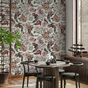 K&ouml;nnte beinhalten: Ein Esszimmer mit einem runden Holztisch und vier schwarzen St&uuml;hlen. Die Wand ist mit einer Tapete mit einem Muster aus roten und schwarzen Koi-Fischen bedeckt, die in Wolken und rosa Blumen schwimmen.