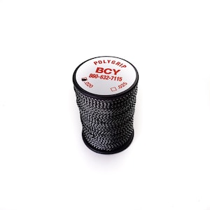 May include: A spool of black and white PolyGrip BCY thread. The spool has a white top with red text and a phone number. The thread is tightly wound around the spool. The thread is .51 mm and .64 mm in diameter.