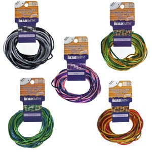 May include: Six spools of Kumihimo braid in various colors, including cool neutrals, earth tones, lilac, evergreen, and wheat berry. Each spool is labeled with the BEADSMITH brand name and the color name.