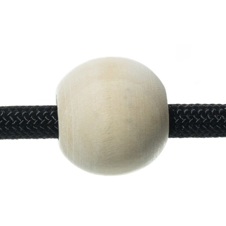 May include: A close-up of a wooden bead strung on a black braided cord. The bead is round and smooth, with a natural wood finish.
