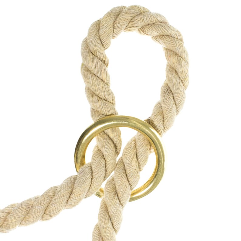 May include: A beige rope with a gold metal ring. The rope is tied in a knot and the ring is attached to the knot.