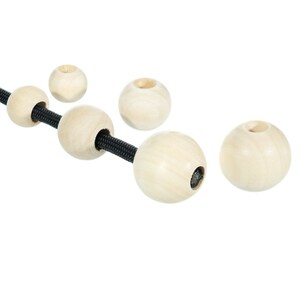 May include: Five wooden beads with a hole in the center, strung on a black cord. The beads are round and smooth, with a natural wood color.