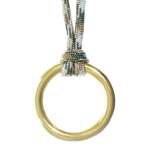 May include: A gold ring pendant with a camouflage cord attached.