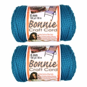 May include: Two spools of teal blue Bonnie Craft Cord, each measuring 6 mm thick and 100 yards long. The label reads "The Perfect Cord for all Fiber Crafts: Knotting, Crocheting, Knitting & Weaving. Le Cordon Parfait pour Tisser, Noeud Tying, Tricotant Crochet & Habilet&eacute;s."