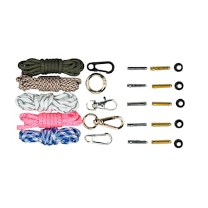 May include: An assortment of crafting supplies, including several spools of colorful rope in green, brown, white, pink, and blue patterns. Also included are black and gold carabiner clips, metal pins, and small black rubber rings.