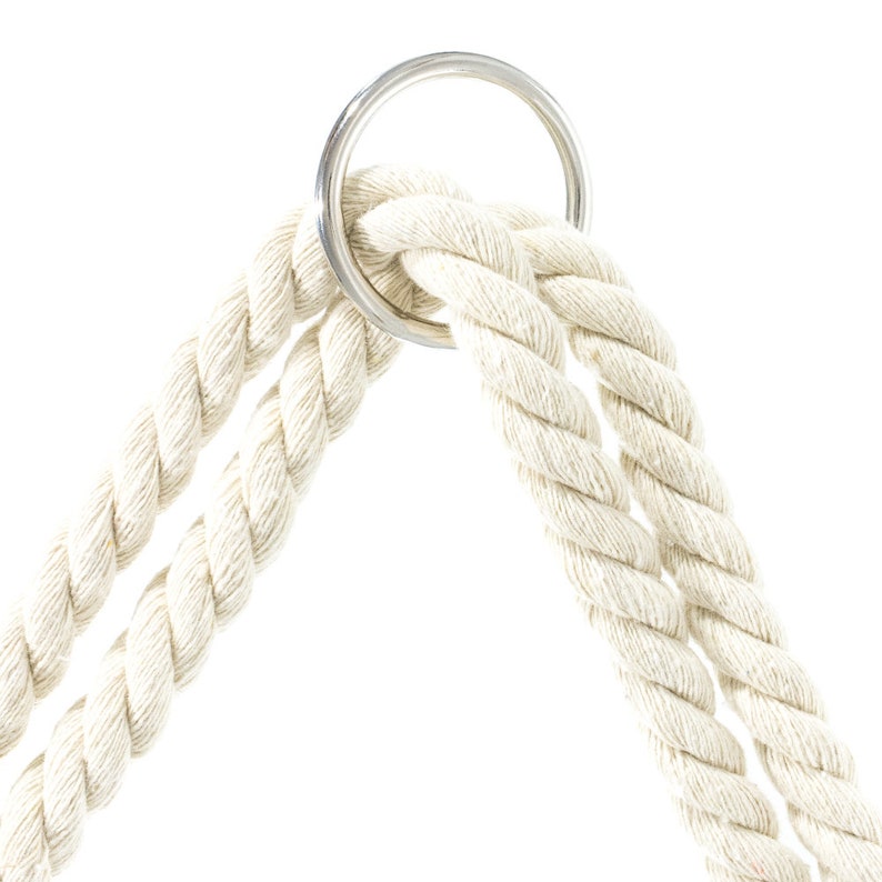May include: Close-up of a white cotton rope with a silver metal ring. The rope is looped through the ring, creating a secure knot.