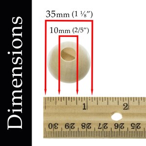 May include: A close-up of a natural wood bead measuring 1 1/8 inches in diameter and 2/5 inches in height. The bead is shown next to a ruler for size reference.