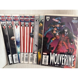 May include: A collection of Marvel comic books, featuring titles like "Wolverine" and "House of M." The comics display vibrant cover art with characters in action poses. The spines show issue numbers, with titles and logos clearly visible.