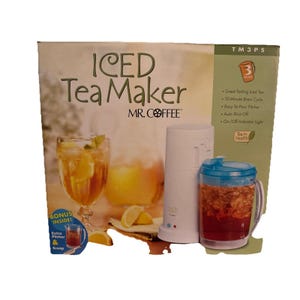 May include: An Iced Tea Maker by Mr. Coffee. The box features a glass of iced tea with lemon slices, a white tea maker, and a pitcher with a blue lid. Text on the box includes "Iced Tea Maker" and "Bonus Inside!"