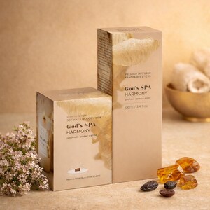 Pode incluir: Duas caixas bege de produtos "God's SPA Harmony", uma vela perfumada e o outro um difusor premium. A caixa da vela tem um gráfico de uma vela e as palavras "patchouli, âmbar, âmbar". O difusor tem o texto "100ml / 3.4 fl oz".