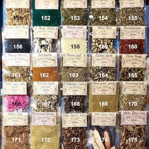 May include: A selection of dried herbs and botanicals, each in a small, labelled bag. The display includes St. John's Wort, Spirulina powder, Spearmint leaf, and others. Each bag is marked with a number and the herb's name.