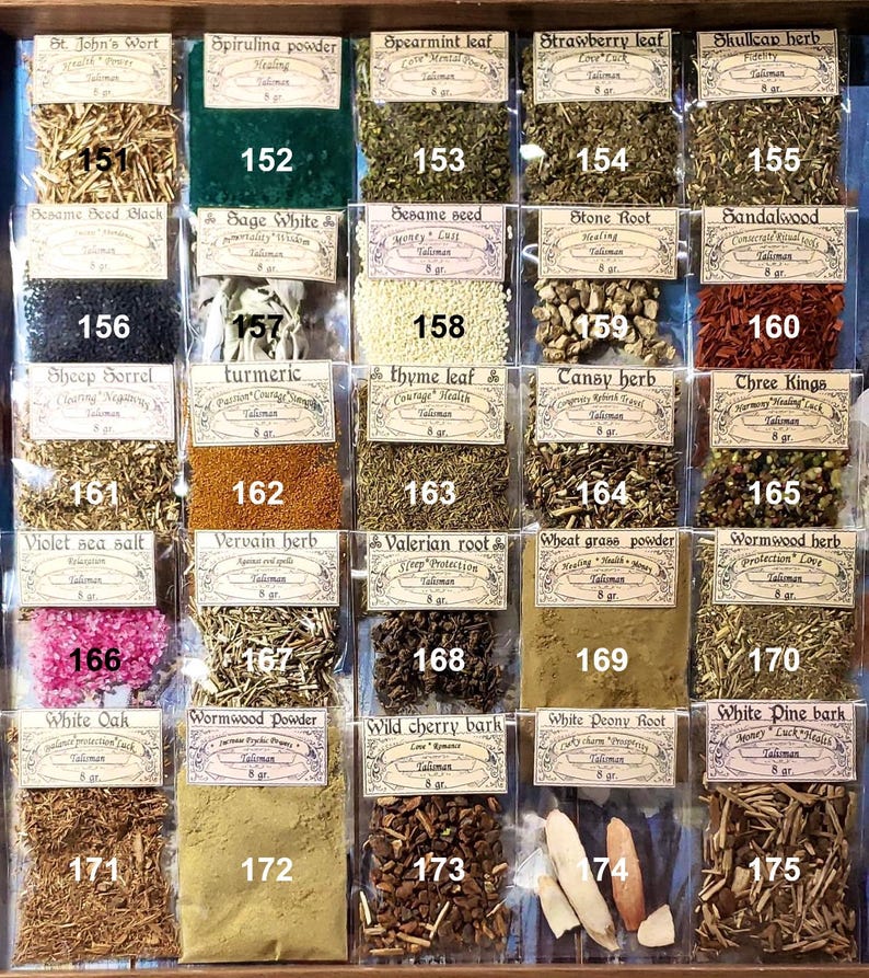May include: A selection of dried herbs and botanicals, each in a small, labelled bag. The display includes St. John's Wort, Spirulina powder, Spearmint leaf, and others. Each bag is marked with a number and the herb's name.