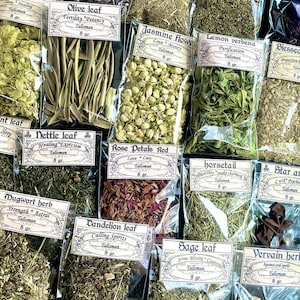 May include: A selection of dried herbs in clear plastic bags, each labelled with a botanical name and purpose. Varieties include olive leaf, jasmine flower, and rose petals. Each bag contains 8 grams of herbs, ideal for talismans.