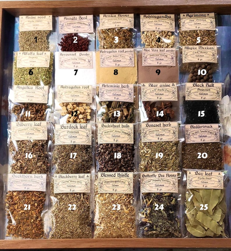 May include: A wooden display case filled with small, labelled packets of dried herbs and spices. The packets are arranged in rows and columns, showcasing a variety of botanical ingredients, including anise seed, arnica flower, and bay leaf.