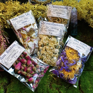 May include: Assortment of dried flower sachets, each with a label describing the flower and its associated meaning. The flowers include white water lily, honeysuckle, chrysanthemum, blue lotus, and rose boutons. Each sachet contains 8 grams of dried flowers.