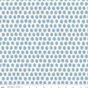 May include: Cream-colored fabric with a repeating pattern of blue oval shapes. The ovals are outlined in white, creating a textured effect. The fabric is measured in inches, with a ruler along the bottom edge.