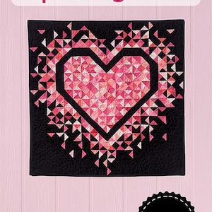 May include: A heart-shaped quilt with a geometric design. The heart is made of pink and white triangles, framed by a black border, set against a black backdrop. The text "MINI Exploding Heart" is at the top. A circular logo at the bottom says "Slice of Pi Quilts."