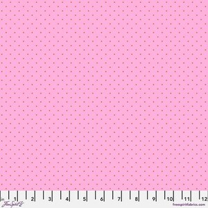 Op de afbeelding: Roze stof met een herhalend patroon van kleine, gelijkmatig verdeelde gouden stippen. Een liniaal langs de onderrand toont de afmetingen in inches. De tekst "Free Spirit" en "freespiritfabrics.com" zijn zichtbaar.