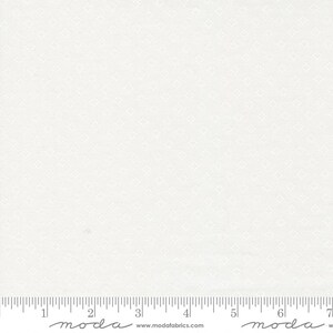 May include: Off-white fabric with a subtle, repeating diamond pattern. The fabric is measured with a ruler in inches, with the brand name "moda" visible at the bottom. The fabric is likely used for quilting or sewing projects.