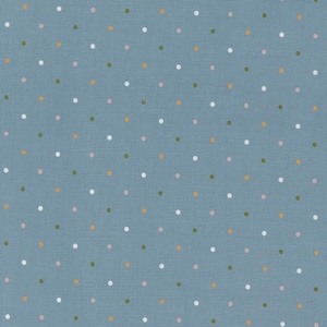 May include: A close-up of a blue fabric with a repeating pattern of small, evenly spaced polka dots. The dots are in various colors, including white, pink, gold, and green. The fabric has a slightly textured appearance.