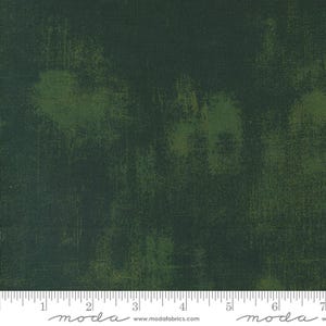 Op de afbeelding: Een donkergroene stof met een subtiele, gemarmerde textuur. De stof heeft een licht verweerde uitstraling, met een vleugje lichtgroen dat op sommige plekken doorschijnt.