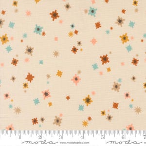 Puede incluir: Tela de color crema con un patrón repetido de explosiones de estrellas coloridas en tonos de marrón, naranja, amarillo, rosa y turquesa. La tela tiene una regla a lo largo del borde inferior, marcada en centímetros.