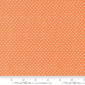 Könnte beinhalten: Orangener Stoff mit einem sich wiederholenden Muster aus kleinen, cremefarbenen Strichen, die in einem Raster angeordnet sind. Ein Lineal in Zoll wird verwendet, um den Stoff zu messen, mit dem "moda"-Logo unten. Der Stoff ist etwa 17,78 cm breit.