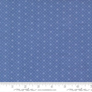May include: Blue fabric with a repeating white floral pattern. The fabric has a ruler along the bottom edge with the word "moda" and the website address www.modafabrics.com printed on it.