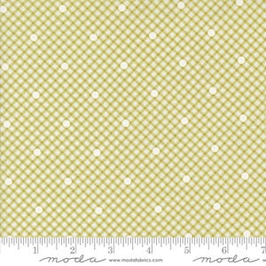 May include: A fabric with a repeating pattern of small white polka dots on a light green and white gingham check background. The fabric is measured in inches along the bottom edge.
