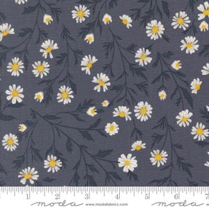May include: A fabric featuring a repeating pattern of white daisies with yellow centres and dark green stems and leaves on a dark grey background. A ruler is along the bottom edge.