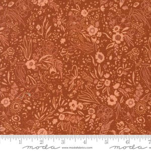 Puede incluir: Primer plano de una tela con un patrón floral repetido. El fondo es de color marrón rojizo cálido, con delicados contornos florales de color melocotón y flores de color melocotón sólido. La tela está marcada con una regla en pulgadas.