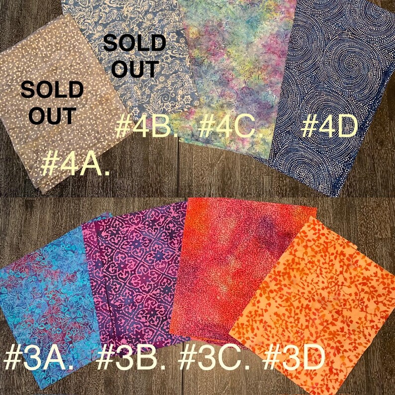 May include: A collection of fabric swatches in various patterns and colors. The swatches are labeled with numbers and some are marked as "SOLD OUT".