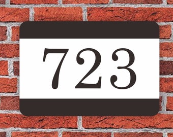 Pode incluir: Uma placa retangular branca com bordas pretas e o número 723 impresso em preto.