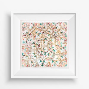 Puede incluir: Una imagen enmarcada en blanco con un patrón de azulejos coloridos. Los azulejos son blancos con diseños florales verdes, rojos y amarillos.