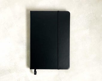 Zwarte A5-notitieboekje en bronskleurige pennenset: minimalistisch briefpapiercadeau