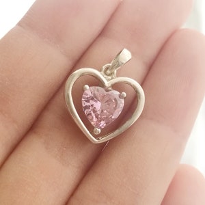 Peut inclure: Un pendentif en argent avec un motif en forme de c&oelig;ur. Le pendentif a un cadre ext&eacute;rieur en forme de c&oelig;ur et une pierre pr&eacute;cieuse rose en forme de c&oelig;ur &agrave; l'int&eacute;rieur. Le pendentif est con&ccedil;u pour &ecirc;tre port&eacute; en collier.