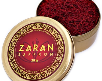 May include: A gold metal tin with a red label that says "Zaran Saffron" and "28g Pure Saffron Threads". The tin is open and filled with red saffron threads.