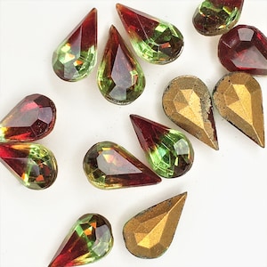 May include: Assortment of teardrop-shaped glass rhinestones in shades of red, green, and gold. The rhinestones have a faceted design and are perfect for crafting and jewelry making.
