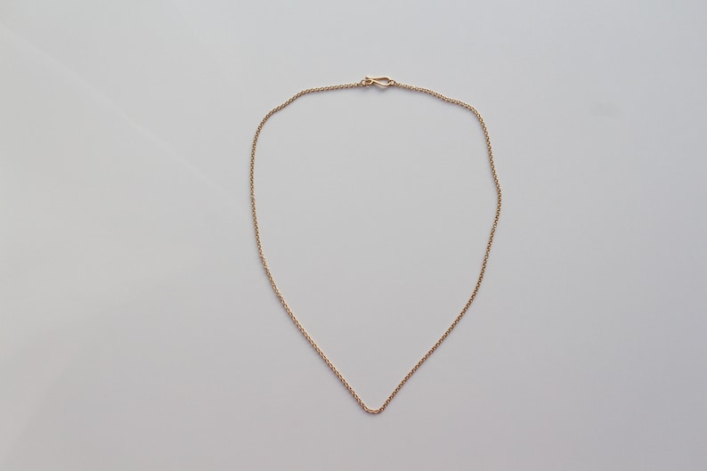 May include: A simple gold chain necklace with a lobster clasp.