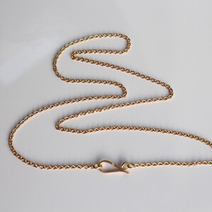 May include: A gold chain necklace with a lobster clasp closure.