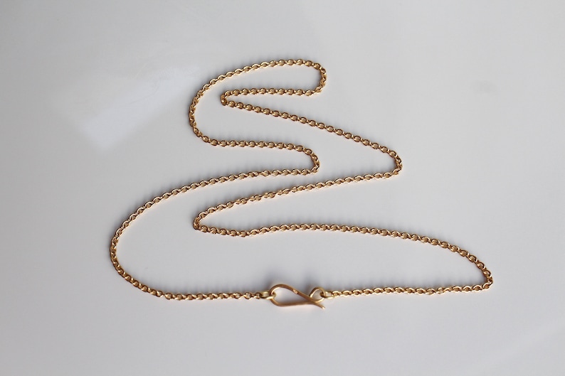 May include: A gold chain necklace with a lobster clasp closure.