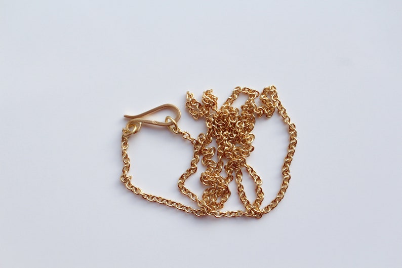 May include: A gold chain necklace with a lobster clasp closure.