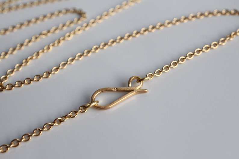 May include: A gold chain necklace with a lobster clasp closure.