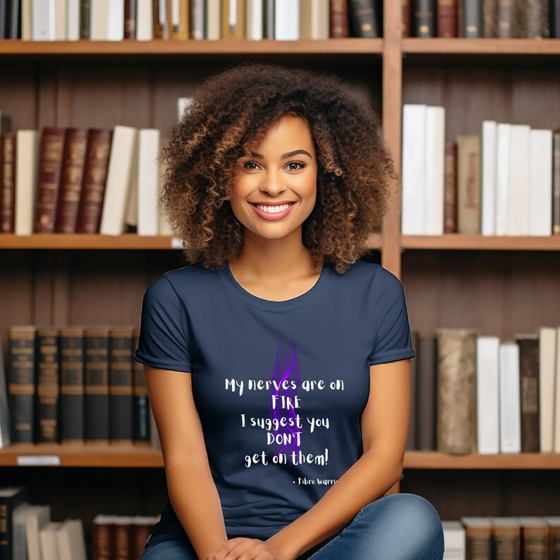 May include: A navy blue t-shirt with a purple flame graphic and the text "My nerves are on FIRE I suggest you DON'T get on them! - Tibre worry".