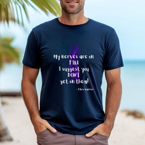 May include: A navy blue t-shirt with a purple flame graphic and the text "My nerves are on FIRE I suggest you DON'T get on them! - Fibro warrior".