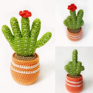 May include: Three crocheted cactus plants in orange pots with white stripes. The cacti are green and have red flowers on top.
