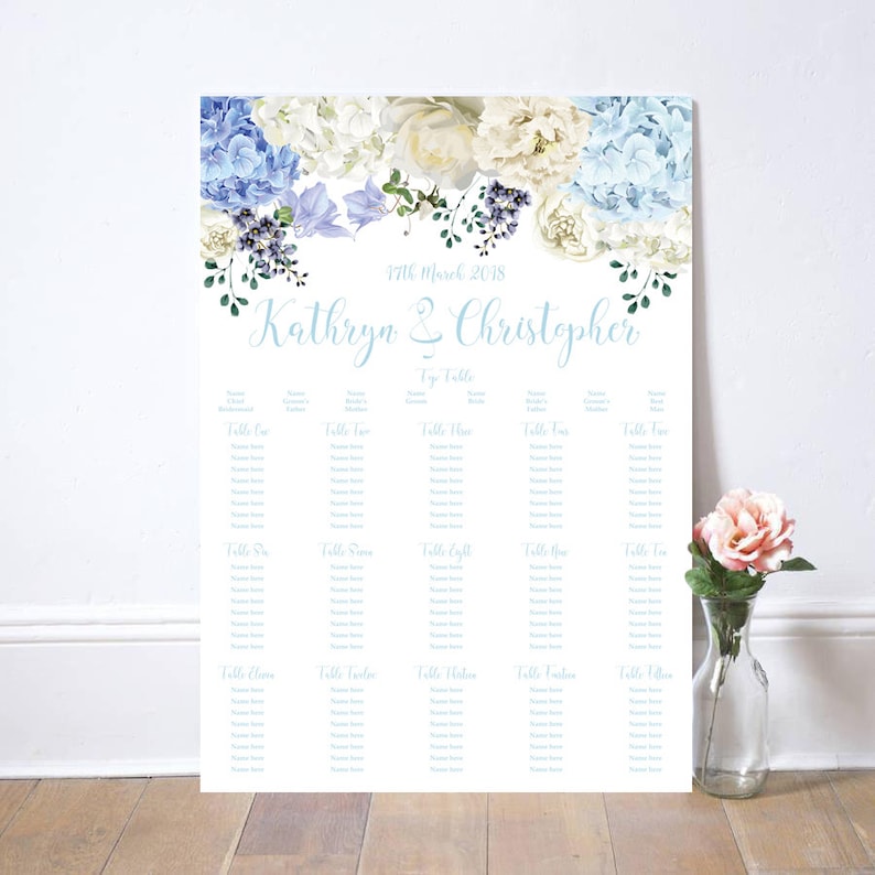 May include: A wedding seating chart featuring a floral design with blue and white hydrangeas and roses. The names "Kathryn & Christopher" are written in a light blue script. The date "17th March 2018" is also displayed.