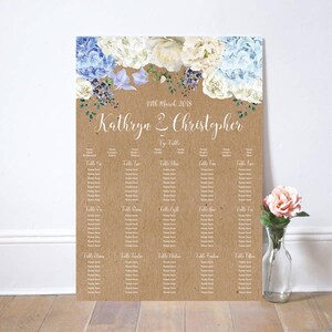 May include: A wedding seating chart printed on a kraft paper background. The top features floral arrangements in white and blue. The names "Kathryn & Christopher" are written in elegant script. The date "17th March 2018" is also displayed.